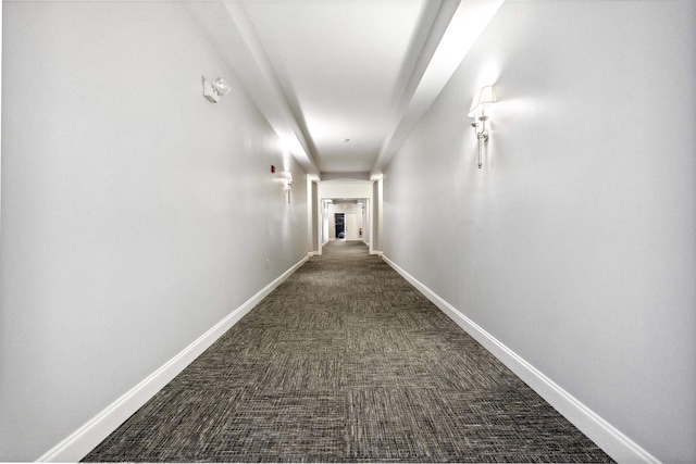 hallway with dark colored carpet