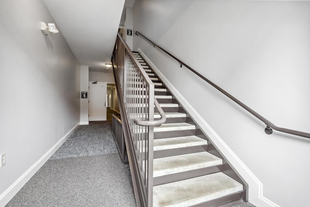 stairway featuring baseboards and carpet
