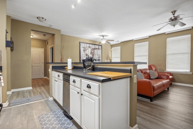 kitchen featuring white cabinets, ceiling fan, a center island, light wood-type flooring, and open floor plan