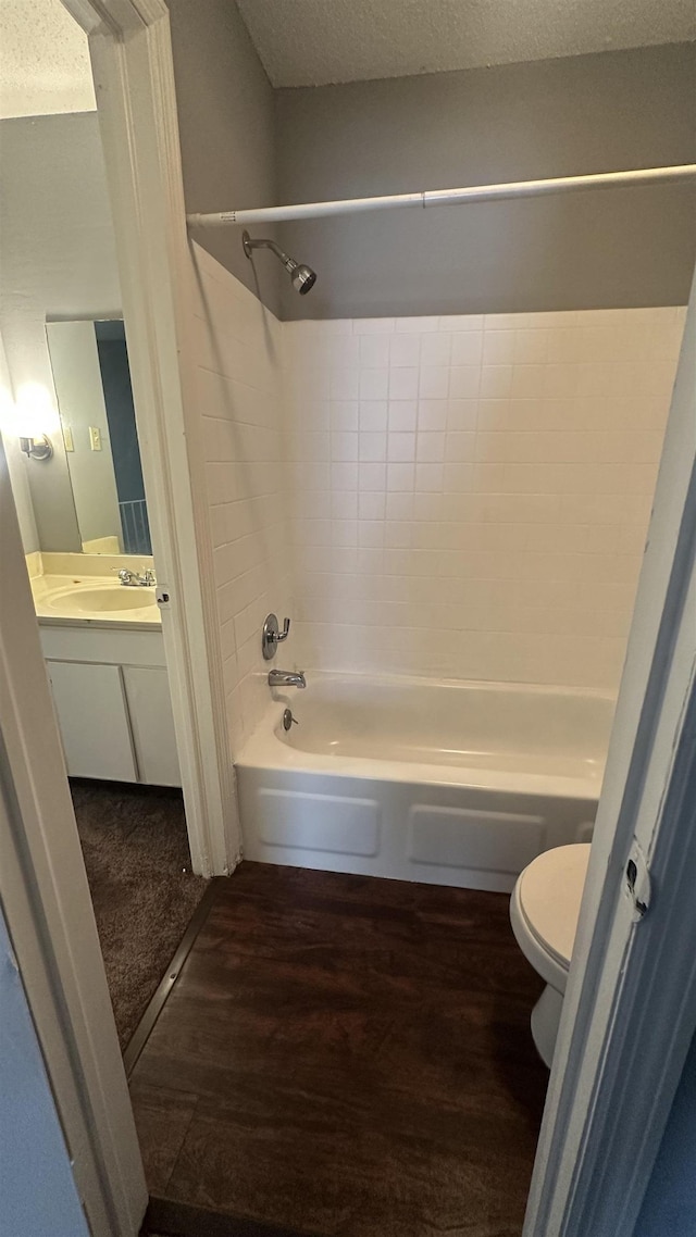 bathroom with toilet, a textured ceiling, shower / tub combination, and vanity