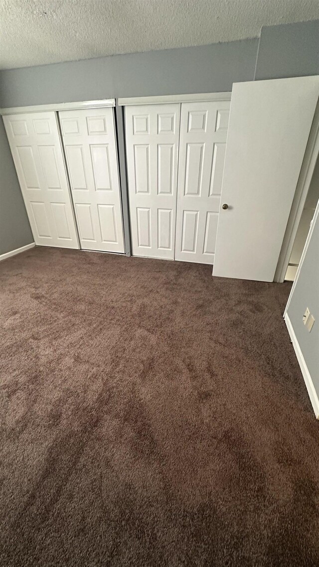 unfurnished bedroom with carpet and a textured ceiling