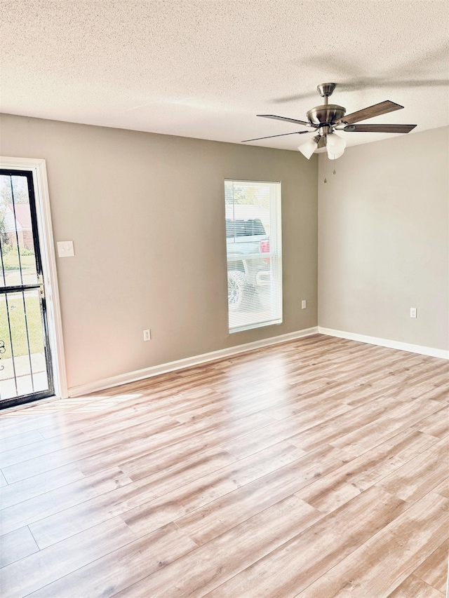 6330 Martinwest Dr, Millington, TN 38053 - spare room featuring light wood-type flooring, a textured ceiling, and a healthy amount of sunlight
