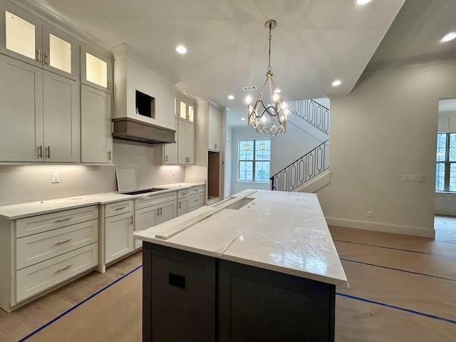 kitchen with a kitchen island, white cabinets, recessed lighting, and baseboards