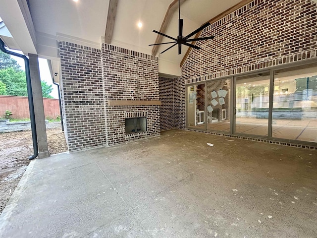 unfurnished living room with a ceiling fan, high vaulted ceiling, and an outdoor brick fireplace