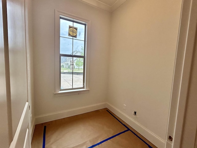 spare room featuring crown molding and baseboards