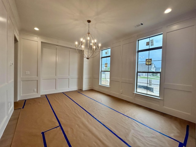 unfurnished dining area featuring visible vents, a decorative wall, recessed lighting, and a chandelier