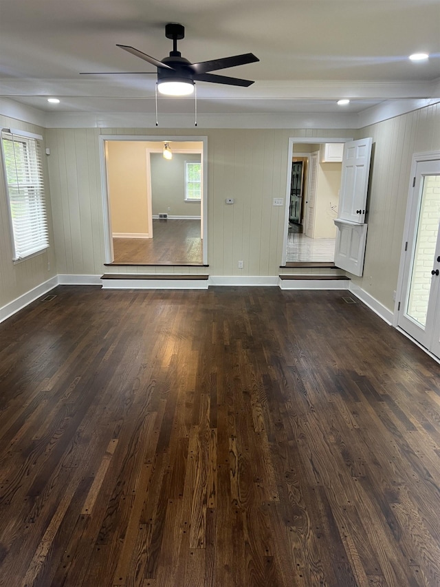 spare room featuring dark wood-type flooring, ceiling fan, and baseboards