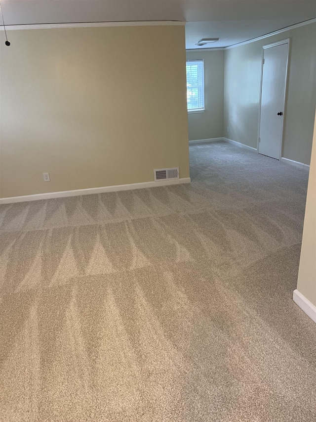 carpeted empty room featuring baseboards and ornamental molding