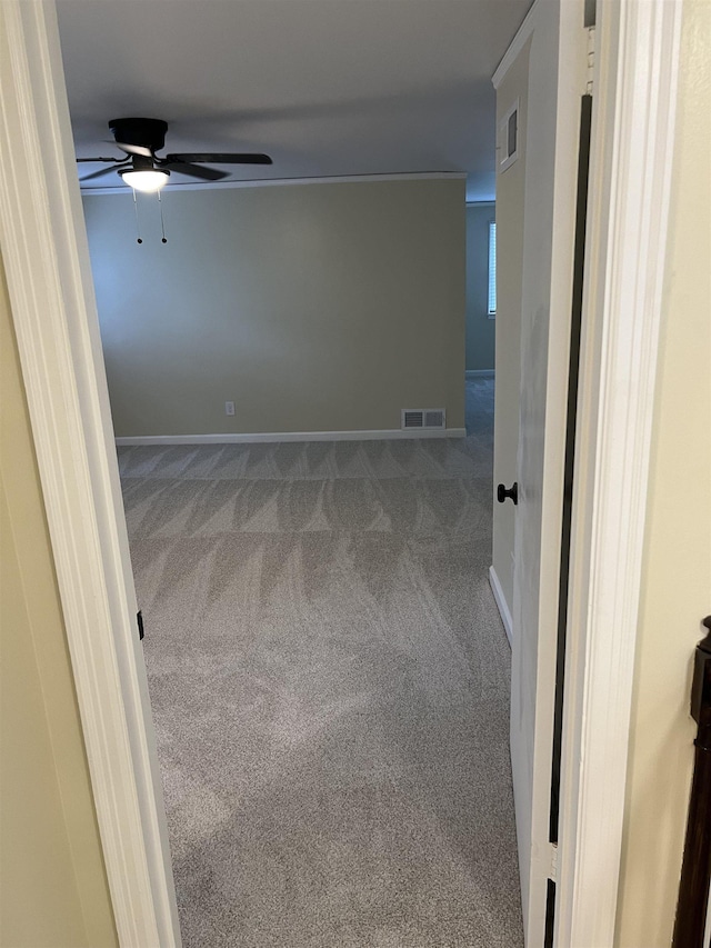carpeted empty room with ceiling fan and baseboards