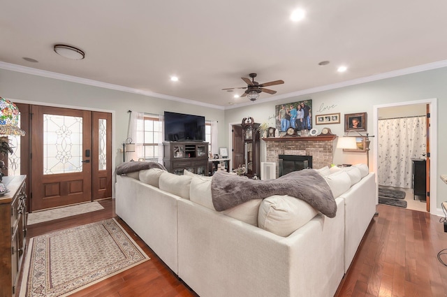 living area featuring recessed lighting, a brick fireplace, ceiling fan, dark wood-type flooring, and crown molding