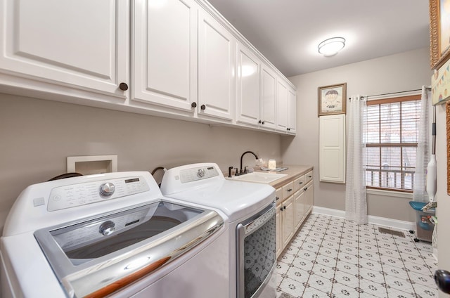 washroom with light floors, cabinet space, washing machine and clothes dryer, a sink, and baseboards