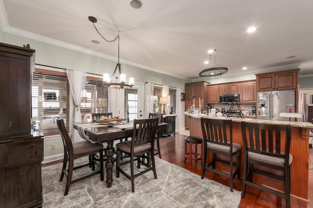 dining space with crown molding, plenty of natural light, a chandelier, and dark wood-type flooring