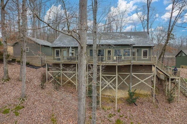 back of property featuring a deck, a shingled roof, and stairs