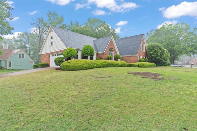 view of front of house with a front yard, driveway, a garage, and brick siding