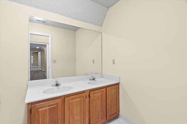 bathroom featuring baseboards, visible vents, double vanity, and a sink