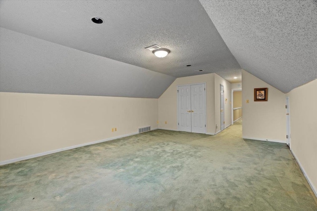 additional living space featuring baseboards, visible vents, carpet floors, and lofted ceiling