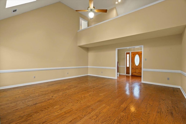 unfurnished living room featuring visible vents, wood finished floors, ceiling fan, baseboards, and high vaulted ceiling