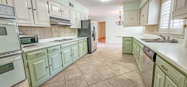 kitchen with under cabinet range hood, stainless steel appliances, visible vents, backsplash, and green cabinetry