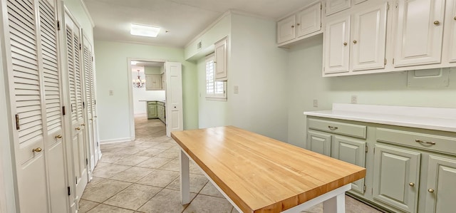 kitchen with white cabinetry, light tile patterned floors, and light countertops