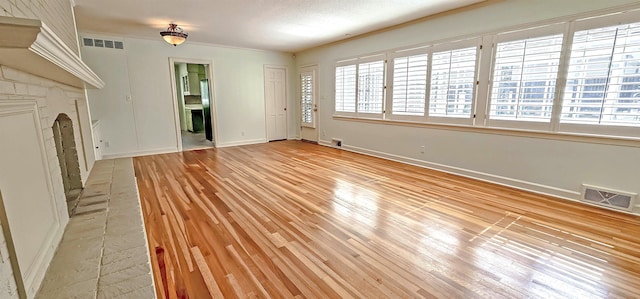 unfurnished living room featuring visible vents, baseboards, and light wood-type flooring