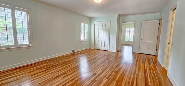 unfurnished bedroom with light wood-type flooring, a closet, and baseboards