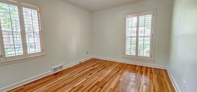 unfurnished room featuring a wealth of natural light and visible vents