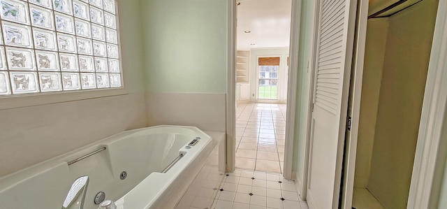 bathroom with tile patterned flooring and a jetted tub