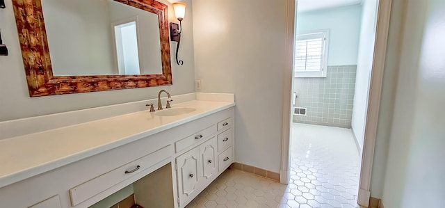 full bath with tile patterned flooring, visible vents, vanity, and tile walls