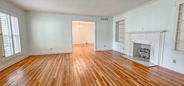 unfurnished living room featuring a notable chandelier, visible vents, built in features, and a healthy amount of sunlight