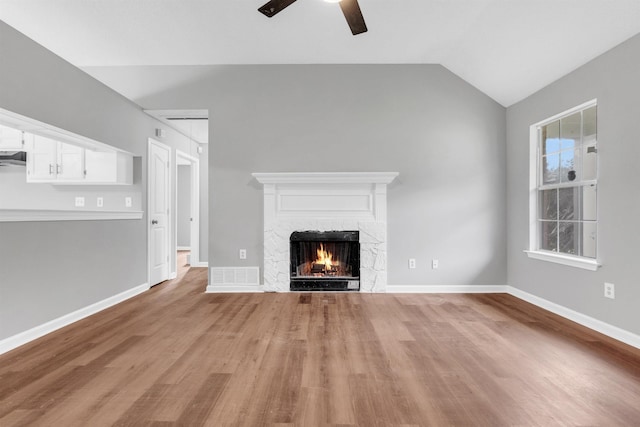 2568 Parkview Dr, Memphis, TN 38128 - unfurnished living room featuring light wood-style floors, ceiling fan, a stone fireplace, and lofted ceiling