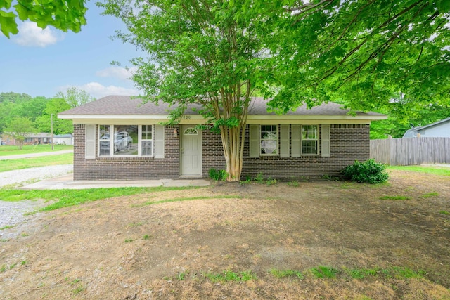 view of front of house featuring fence and brick siding