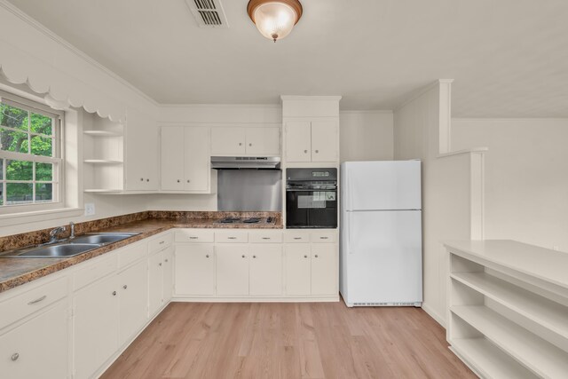 kitchen featuring under cabinet range hood, open shelves, visible vents, black oven, and freestanding refrigerator