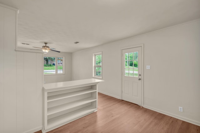 foyer entrance with a healthy amount of sunlight, ceiling fan, baseboards, and light wood-style floors