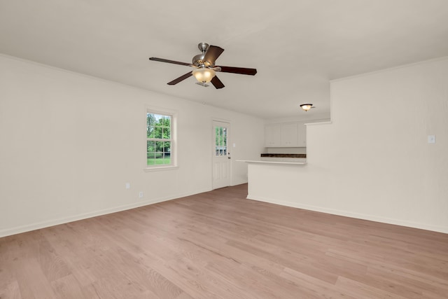 unfurnished living room featuring a ceiling fan, light wood-style flooring, and baseboards