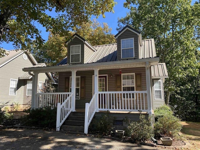 new england style home with a porch and metal roof