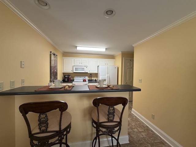 kitchen with a breakfast bar, dark countertops, white appliances, and a peninsula