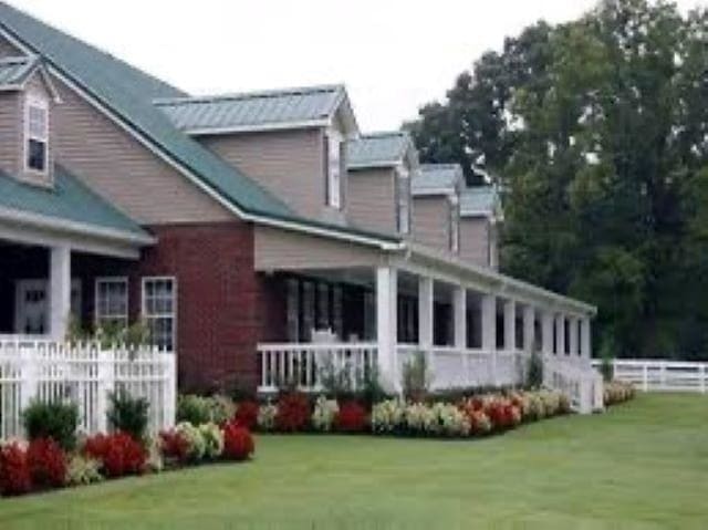 back of property with fence and a lawn