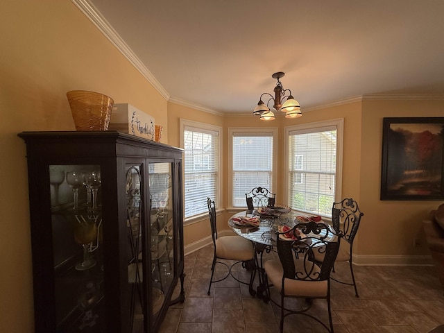 dining room with a chandelier, baseboards, dark tile patterned floors, and crown molding