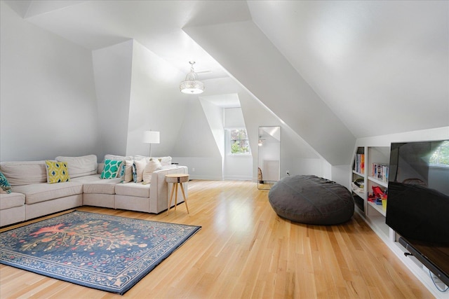 living area with wood finished floors and vaulted ceiling