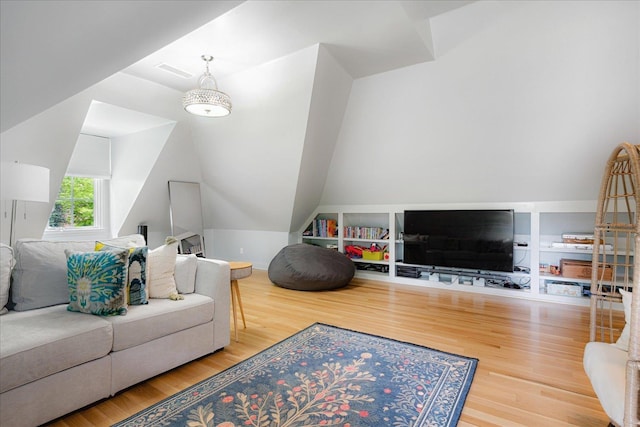 living room featuring wood finished floors, visible vents, and vaulted ceiling