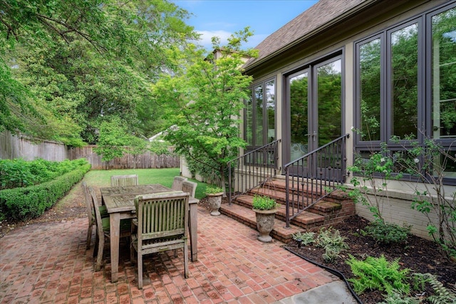 view of patio with outdoor dining space, french doors, and a fenced backyard