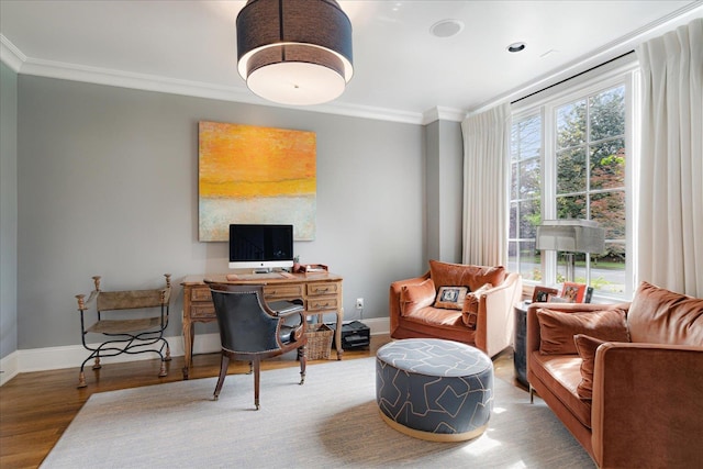 living area with baseboards, wood finished floors, and crown molding
