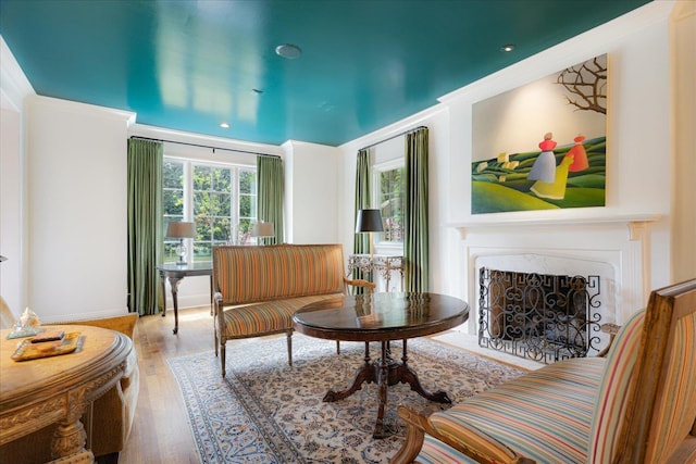 living area featuring a fireplace with flush hearth and wood finished floors