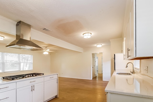 4143 Hilldale Ave, Memphis, TN 38117 - kitchen with a sink, stainless steel gas cooktop, a textured ceiling, and wall chimney exhaust hood