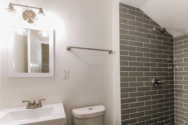 4143 Hilldale Ave, Memphis, TN 38117 - bathroom with a tile shower, toilet, a textured ceiling, and a sink