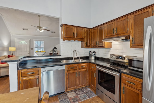 kitchen featuring a sink, stainless steel appliances, under cabinet range hood, visible vents, and ornamental molding