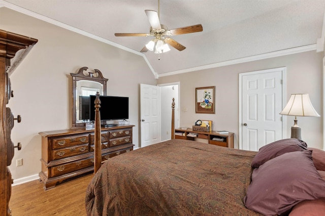 bedroom with light wood-style floors, crown molding, baseboards, a ceiling fan, and lofted ceiling