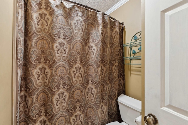 bathroom featuring a textured ceiling, toilet, crown molding, and a shower with curtain