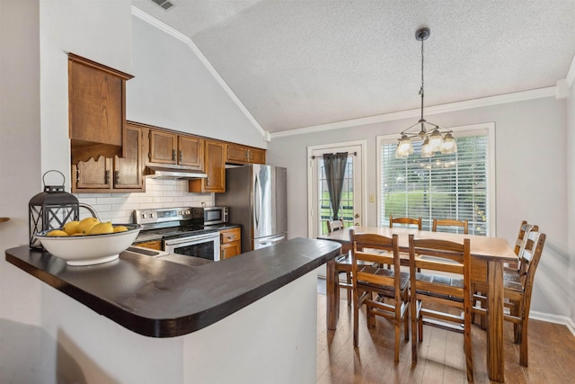 kitchen featuring ornamental molding, dark countertops, brown cabinetry, and stainless steel appliances
