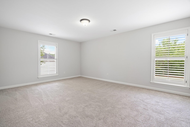 unfurnished room with visible vents, carpet flooring, and baseboards